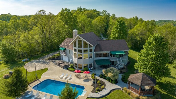 A large house with a swimming pool, outdoor seating, and a covered patio. - Among the Trees - The Lodge (Logan)