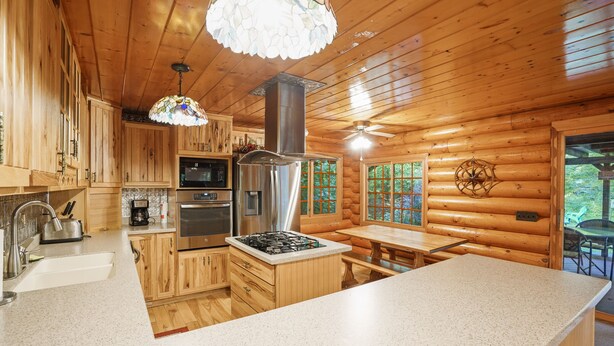 L’intérieur d’un chalet en bois comprend une cuisine, un coin repas et une grande fenêtre.