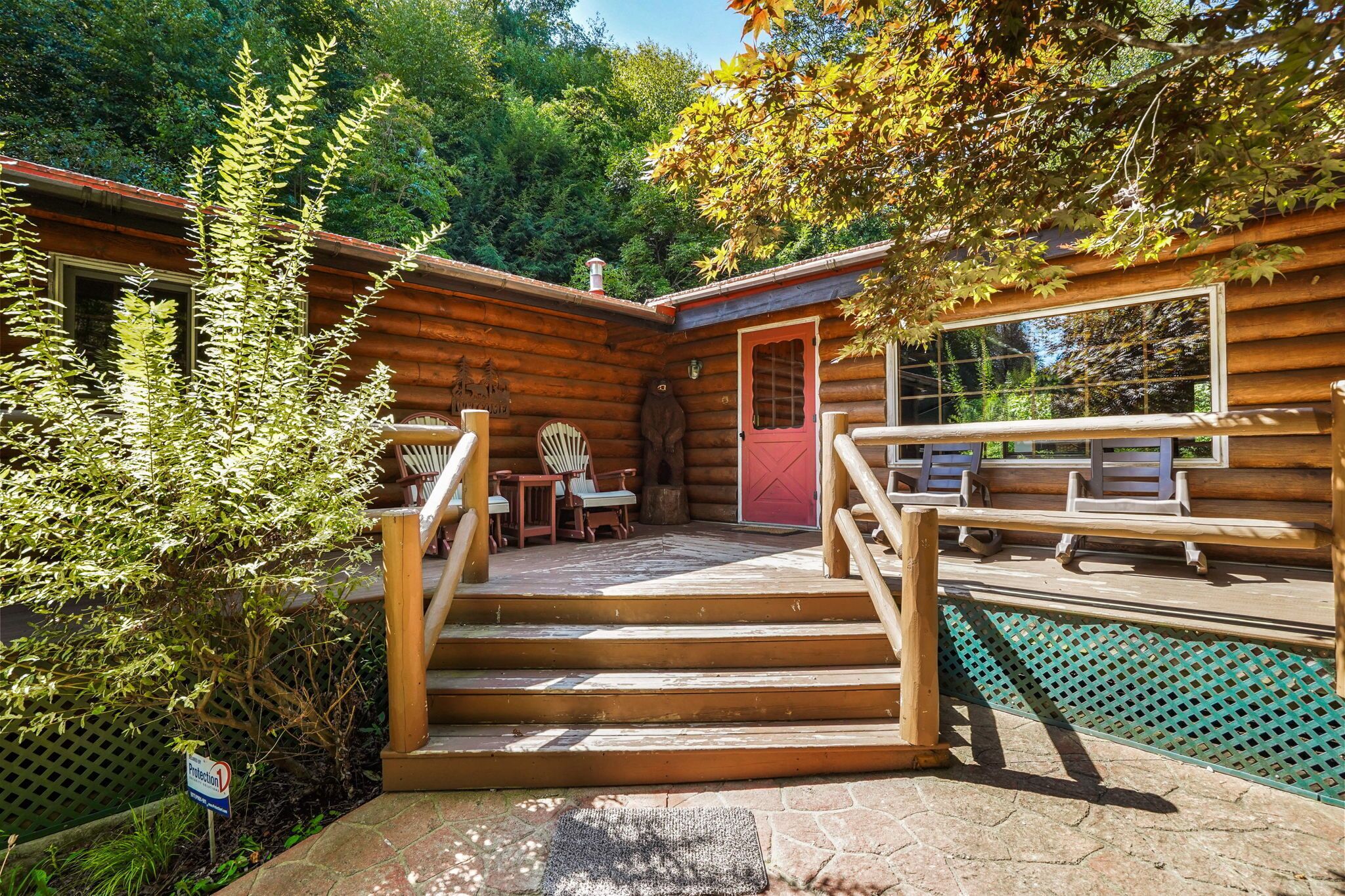 A wooden cabin with a stone staircase leading to a deck area.