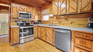 Une cuisine avec des meubles en bois, des appareils électroménagers en acier inoxydable et un lave-vaisselle.