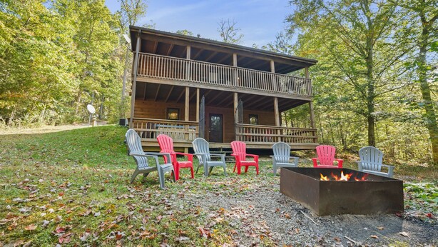 Une cabane dotée d’une terrasse, d’un espace salon extérieur et d’un foyer.