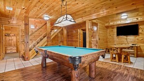 A wooden interior with a pool table, a staircase, and a television. - White Oak Cabin | Hocking Hills, Hot Tub, Rec Room (Rockbridge)