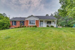 A two-story house with a front porch, brick exterior, and a well-maintained lawn.