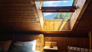 A cozy wooden room with a skylight, a bed, a nightstand, and a chair. - ATI Chalet-style apartment from the 1800s in the heart of Ortisei (Ortisei)
