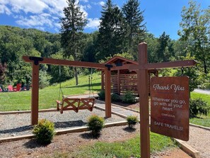 Relax in a serene natural setting, surrounded by lush greenery and a wooden structure, perfect for a peaceful retreat.