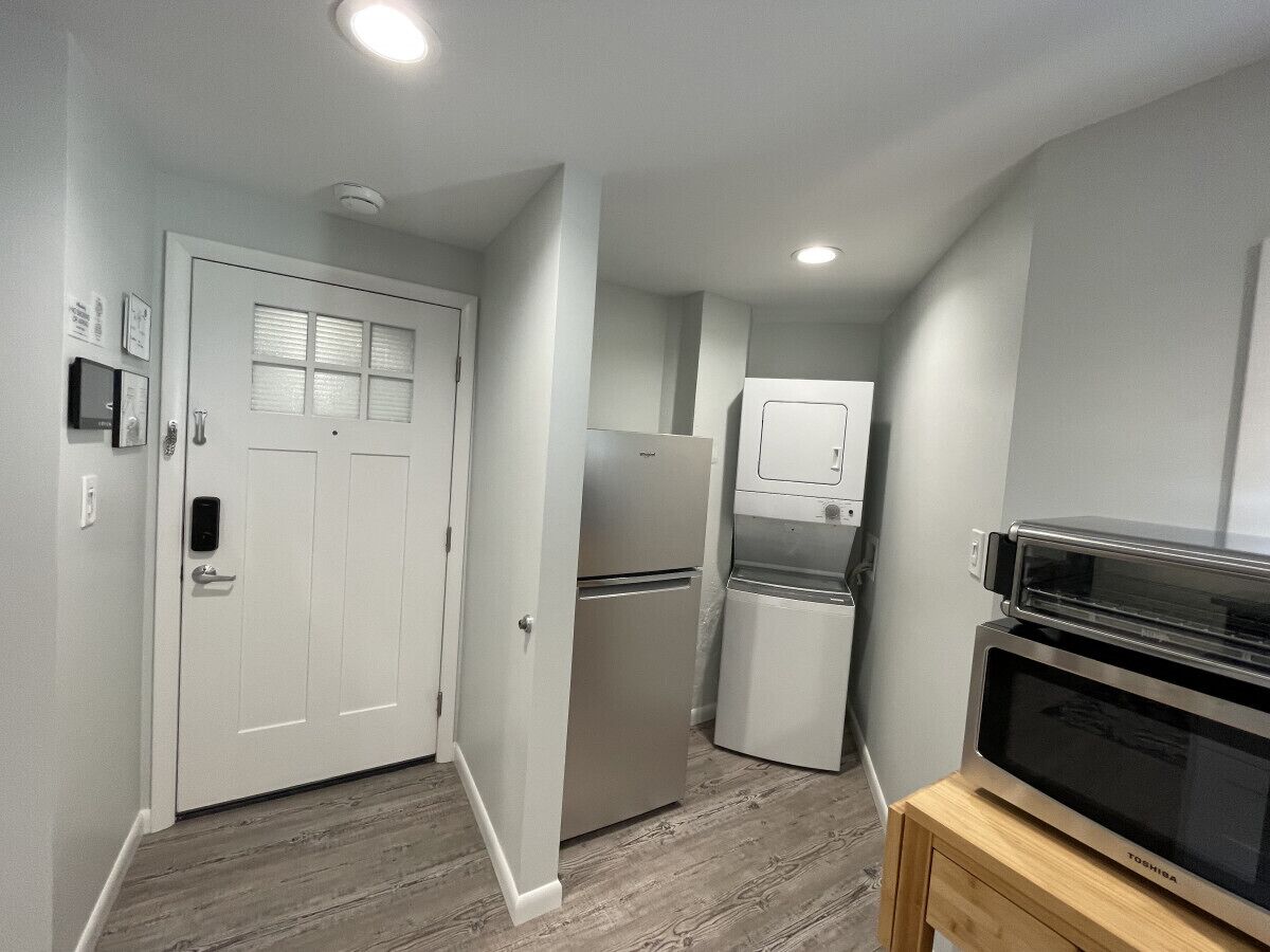 A compact kitchen with a refrigerator, microwave, and oven.