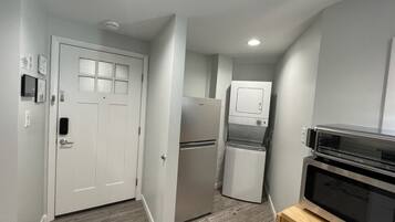 A compact kitchen with a refrigerator, microwave, and oven.