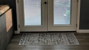 A double door with a sign above reading "WELCOME to the DECK" and "SIT BACK AND RELAX".