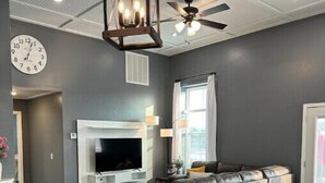 A modern kitchen with a central island, a built-in oven, and a ceiling fan.