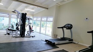 A gym with exercise equipment, large windows, and a treadmill. - Lofts 1B/R Lounge w/WiFi|Gym|near National Stadium (Kingston)