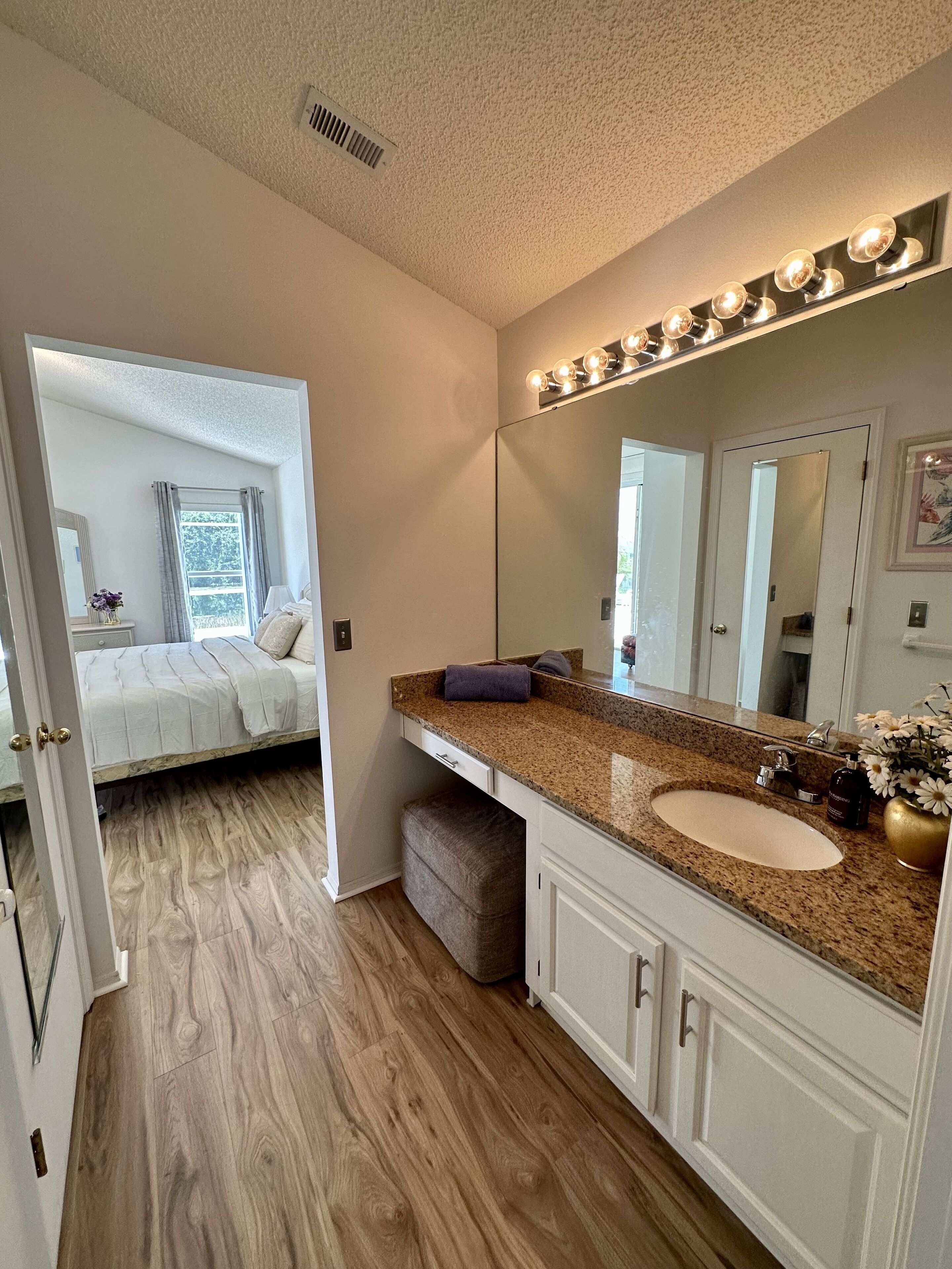 A modern bathroom with a vanity, sink, and mirror.