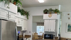 A modern kitchen with white cabinets, stainless steel appliances, and wooden flooring. - Private pool with a beautiful view overlooking the lake! Near Disney & Universal (Kissimmee)