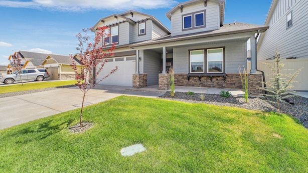 A modern two-story house with a front porch, a garage, and a well-maintained lawn. - New 2 level Twin Falls Home, 2 masters! (Twin Falls)