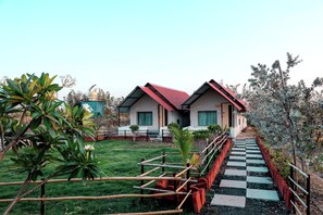A residential property with a paved pathway leading to a house with a red roof.