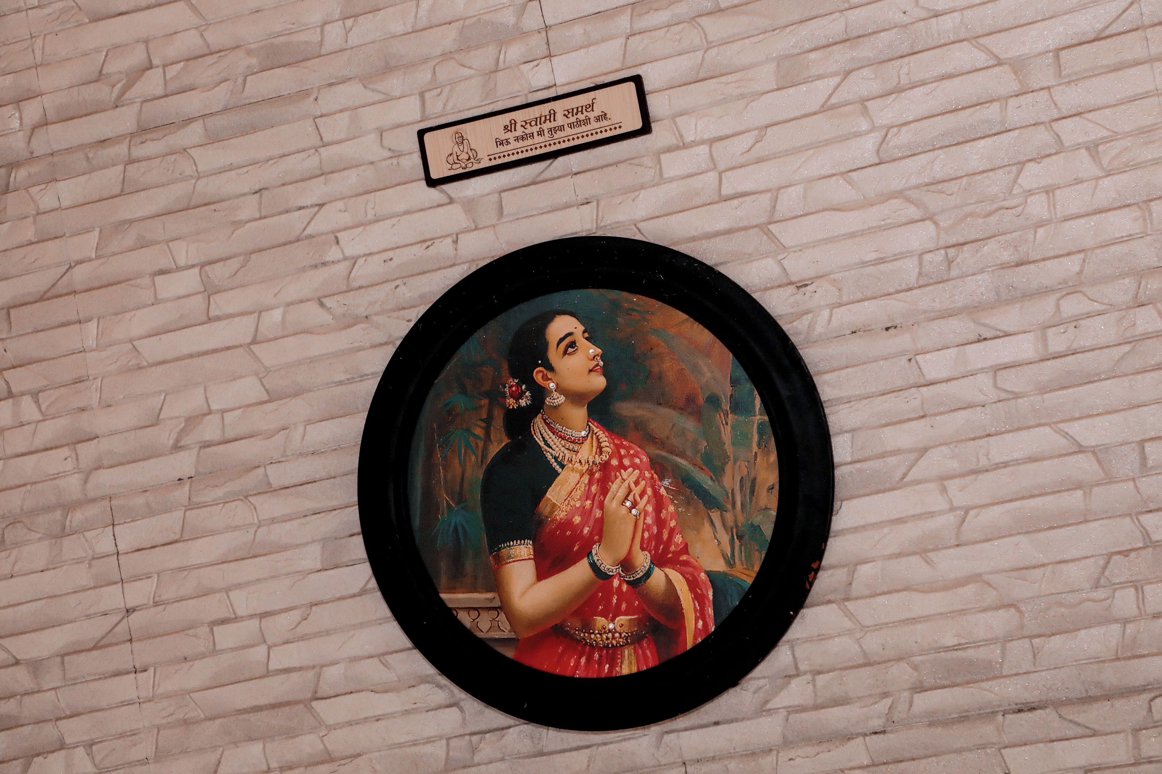 A framed artwork on a brick wall.