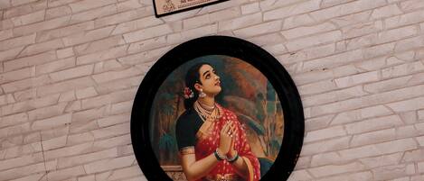 A framed artwork on a brick wall.