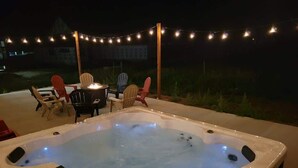 A hot tub with a fire feature, surrounded by chairs and string lights. - Pickleball Playhouse, Hot Tub, Theater, Game Room! (Lava Hot Springs)