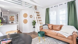Moderni olohuone, jossa on keittiö, ruokailutila ja portaikko.