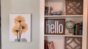 A white cabinet with shelves containing books, a globe, and decorative items.