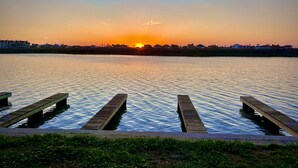 A sunset over a calm lake with a dock in the foreground.