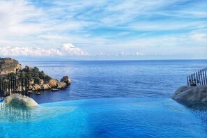 On aperçoit clairement une piscine, avec un littoral rocheux et une île au loin.
