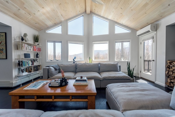 Open floor plan living room with cathedral ceiling facing mountain views.