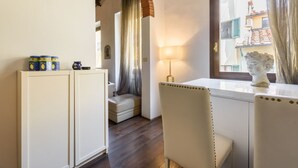 Una habitación con ventana, lámpara, estatua y un banco.