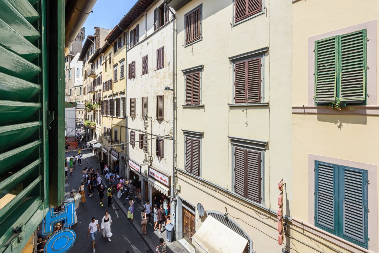 A narrow street lined with multi-story buildings, some with visible signage.