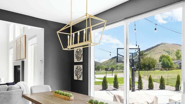 Un comedor moderno con una mesa de madera, sillas blancas y negras, y vistas a un jardín ajardinado con una montaña al fondo.