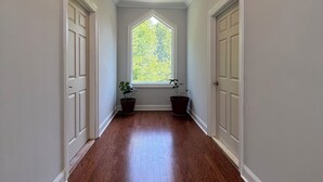 A hallway with hardwood floors, white walls, and a skylight. - Modern Getaway Retreat House on 2 Acres (Poughkeepsie)
