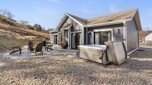 Una casa moderna con un patio que incluye mobiliario exterior y una bañera de hidromasaje.