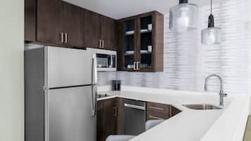 Een koelkast met diepvriezer, een microgolfoven, een vaatwasser