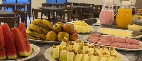 A buffet with various fruits and beverages.