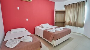A hotel room with two beds, red walls, a wardrobe, and a window with curtains. - Hotel Monte Libano (Florianópolis)