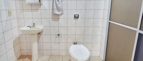 A bathroom with a sink, toilet, and mirror.