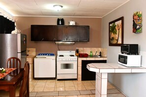 A kitchen with a refrigerator, stove, microwave, and cabinets. - Papaya Dreams (San Juan)
