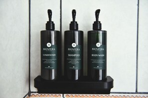 Three bottles of Biosfera products on a black tray against a tiled wall. - Papaya Dreams (San Juan)