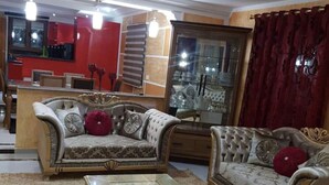 A living room with two sofas, a glass coffee table, and a red curtain. - Villa Romantique Avec Piscine à 5 min de la Plage (Djerba Midun)