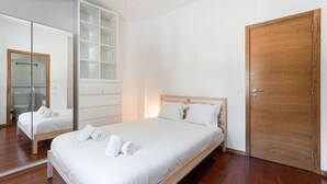 Un dormitorio con una cama de madera, un espejo grande y un armario.