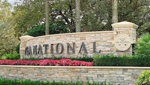 A stone wall with the words "PGA NATIONAL" and a logo.