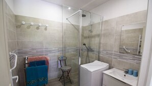 A modern bathroom with a glass-enclosed shower, a white sink, and a chair. - Appartement à Caudecoste, proche d'Agen (CAUDECOSTE)