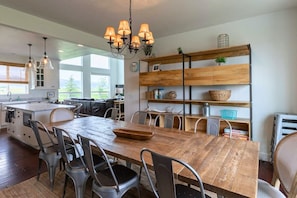 Una cocina amplia con una mesa de madera, sillas de metal y un candelabro.
