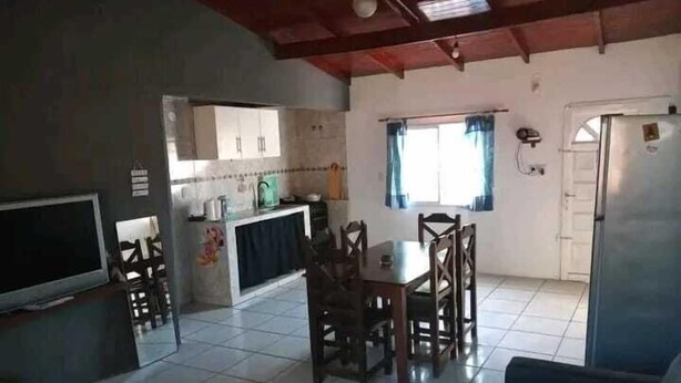 Un espacio habitable pequeño con cocina, comedor y televisor.