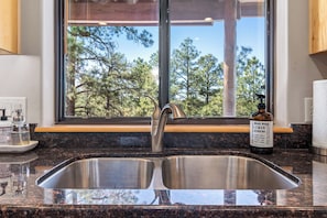 Enjoy a kitchen with a double sink and a window overlooking the surrounding trees.