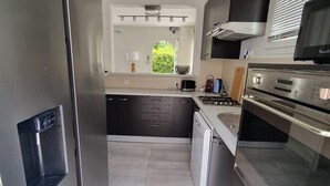 Una cucina moderna con elettrodomestici in acciaio inossidabile, lavastoviglie e forno integrato.