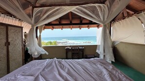 Une chambre avec un lit, un bureau et une vue sur l’océan.