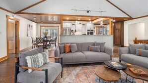A spacious living area with a gray sectional sofa, a wooden coffee table, and a patterned rug. - Mountaintop Ridge | Near Asheville with Pool, Fire Pit, and Ranging Views (Fairview)