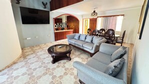 A living room with a sofa, coffee table, and a staircase. - Hotel 1325 (Bani)