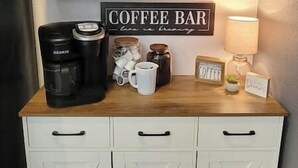 A kitchen area with a coffee bar setup, including a coffee maker, mugs, and a sign that reads "COFFEE BAR". - Coal Creek Cottage (hot tub, dog and kid friendly) (Sedro-Woolley)