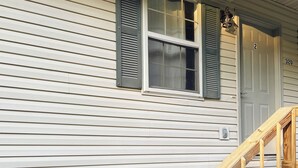 Una casa con una escalera de madera que conduce a una puerta con el número 320.